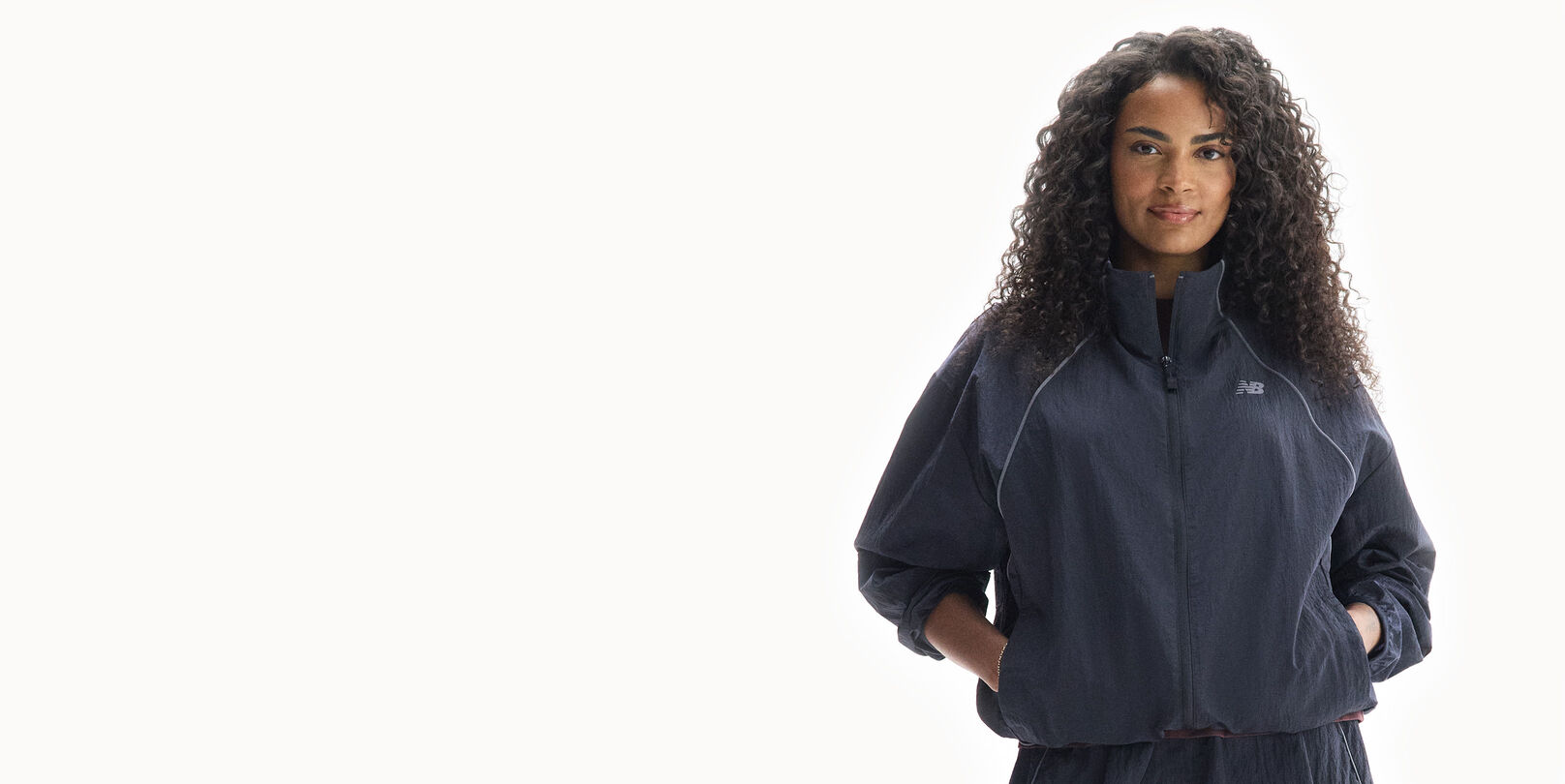 Sydeon, a New Balance ambassador, standing in the Trackside Woven jacket. 